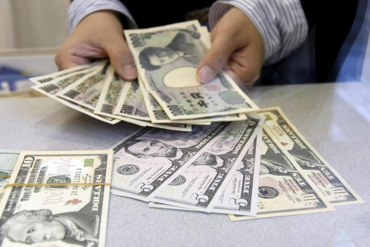 File photo of a teller counting Japanese yen at a foreign exchange booth at a business district in Tokyo